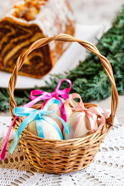 Basket of easter eggs. Traditional poppy seed cake in the back — Stock Photo, Image