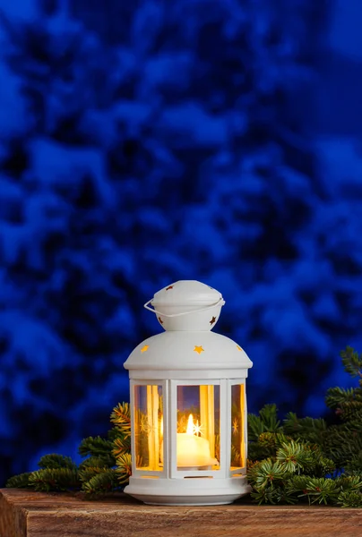 Beyaz fener rustik ahşap masa üzerinde çam dalları arasında. karlı — Stok fotoğraf