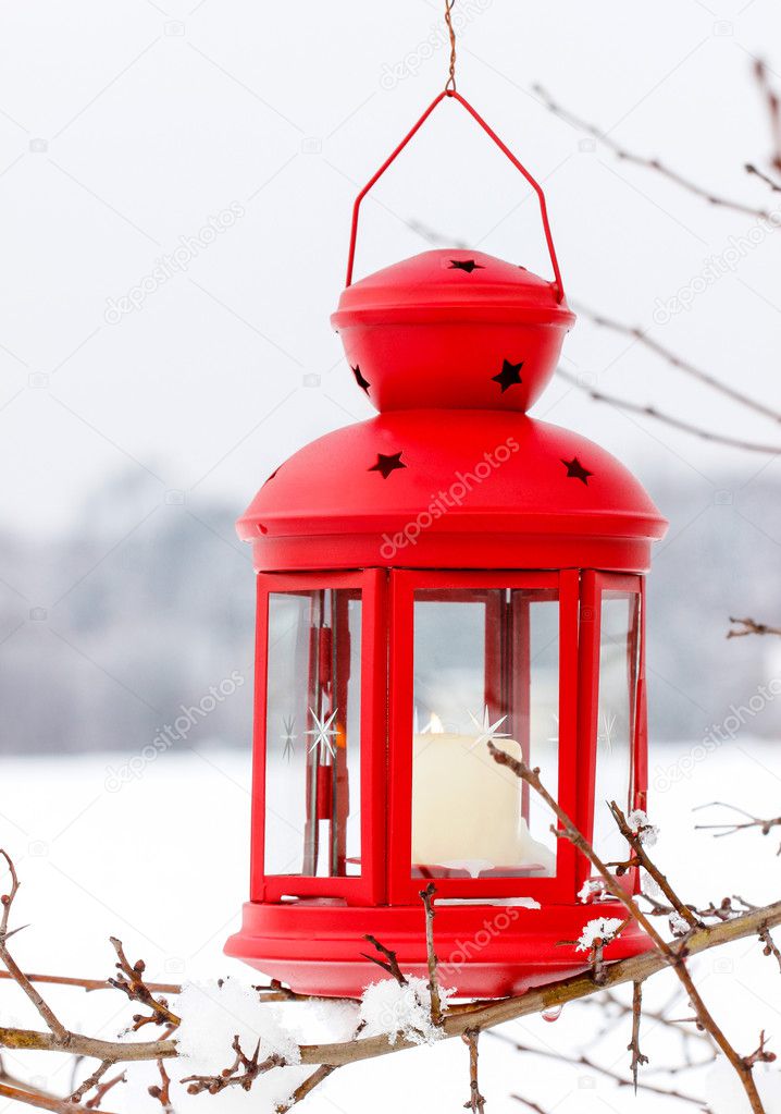 Red lantern hanging on the tree. Snowy morning in the garden.