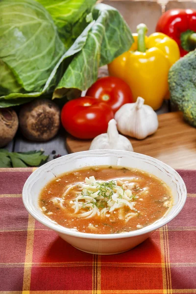 Tomato soup and fresh raw vegetables in the background — Stock Photo, Image