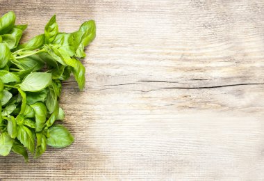 Ahşap arka planda fesleğen yaprakları. Boşluğu kopyala