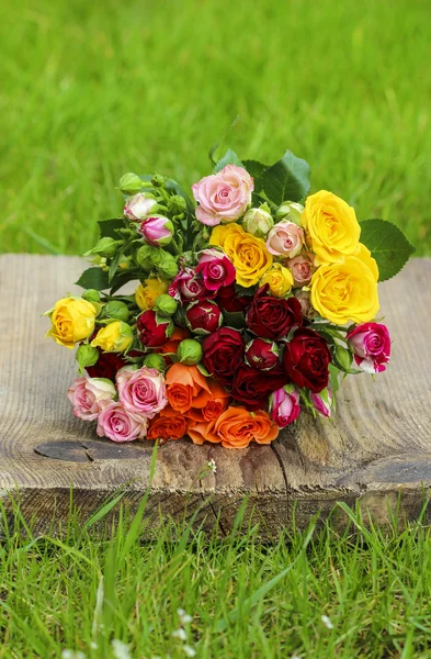 Fabuleux bouquet de roses colorées sur plateau en bois au sprin frais — Photo