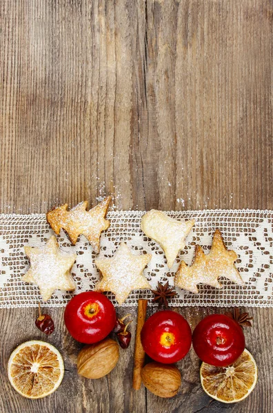 Biscoitos de Natal, maçãs e nozes na mesa de madeira. Espaço de cópia — Fotografia de Stock