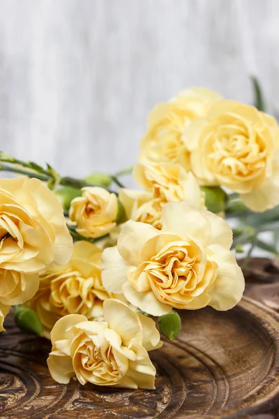 Gelbe Nelkenblüten auf hölzernem Hintergrund. Selektiver Fokus — Stockfoto