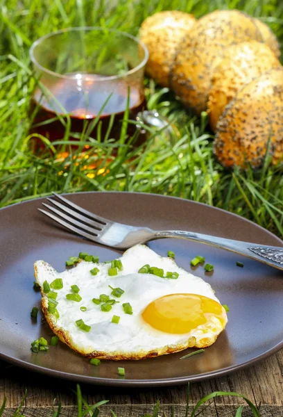 Snídaně v trávě. sázené vejce na hnědé deska — Stock fotografie