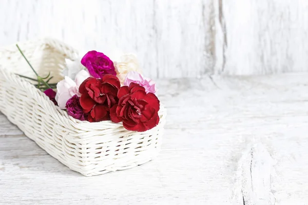 Rode, roze en witte carnation bloemen in rieten mand — Stockfoto