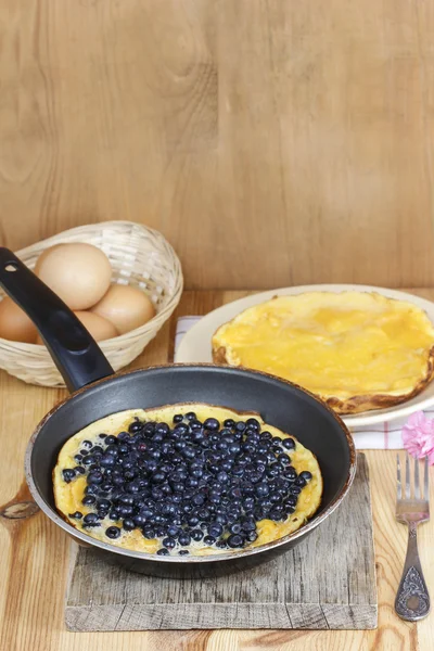 Omelette with blueberries on frying pan — Stock Photo, Image