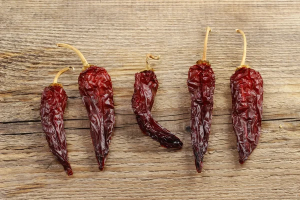 Sušené red hot chili papričky na dřevěné pozadí — Stock fotografie