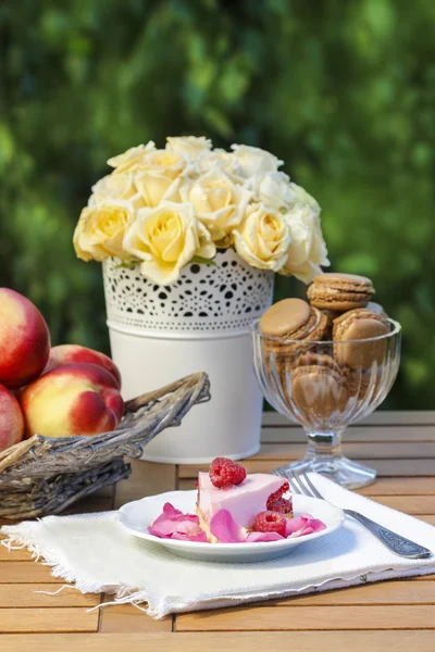 Piece of raspberry cake on wooden table in the garden. — Stock Photo, Image