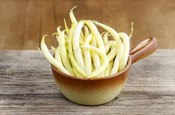 Haricots jaunes dans un bol brun sur une table en bois. Espace de copie — Photo