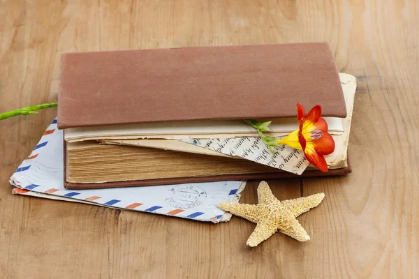 Dagboek, oude brieven en rode freesia bloem op houten tafel — Stockfoto
