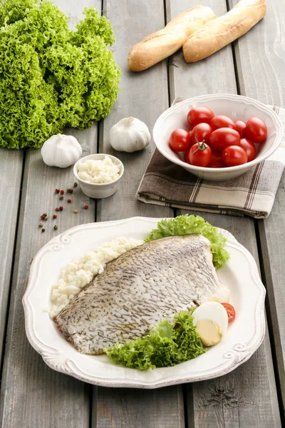Fried cod on white plate with fresh vegetables and egg — Stock Photo, Image