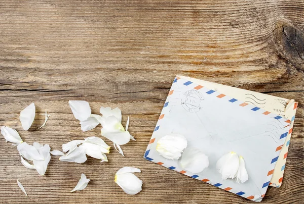 Två gamla brev och rosenblad på trä bakgrund. kopia utrymme — Stockfoto