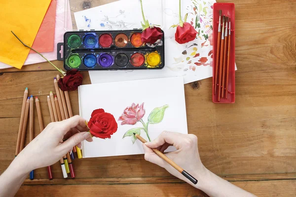 Artista profissional pintando uma rosa em folha branca de papel — Fotografia de Stock