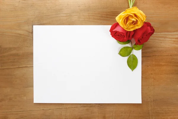 Czerwone i żółte róże na drewniane tła. pusty arkusz papieru, — Zdjęcie stockowe