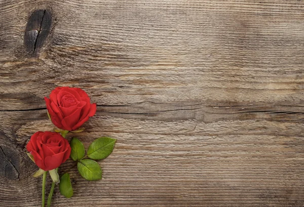 Rosas rojas sobre mesa de madera. Tablero en blanco, espacio de copia —  Fotos de Stock