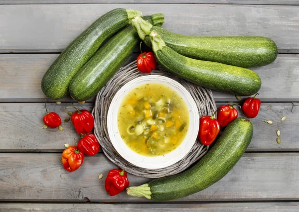 Top view of vegetable soup on wooden table. Raw vegetables aroun — Stock Photo, Image