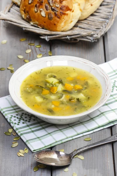 Zuppa di verdure sul tavolo di legno. Cesto con pane fresco nel b — Foto Stock