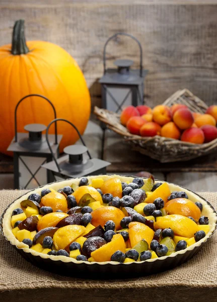 Tart with peach, pumpkin, plum and blueberry in autumn setting — Stock Photo, Image