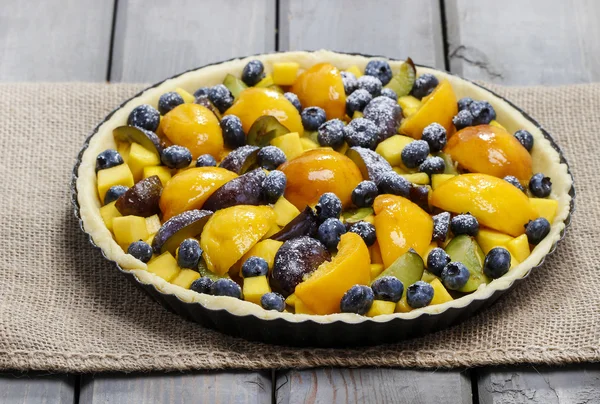 Tart with peach, pumpkin, plum and blueberry in autumn setting — Stock Photo, Image