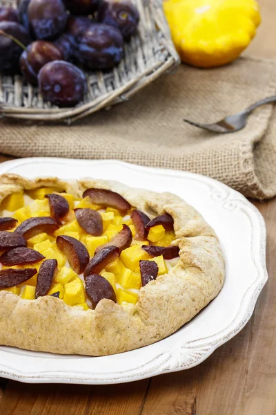 Pumpkin, plum and apricot galette on wooden table — Stock Photo, Image