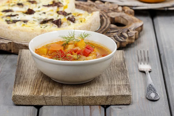 Misku polévky rajče a paprika na dřevěný stůl. podzimní nastavení. — Stock fotografie