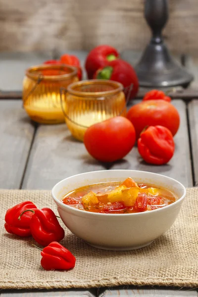 Skål med tomat och paprika soppa på träbord. höstens inställning. — Stockfoto