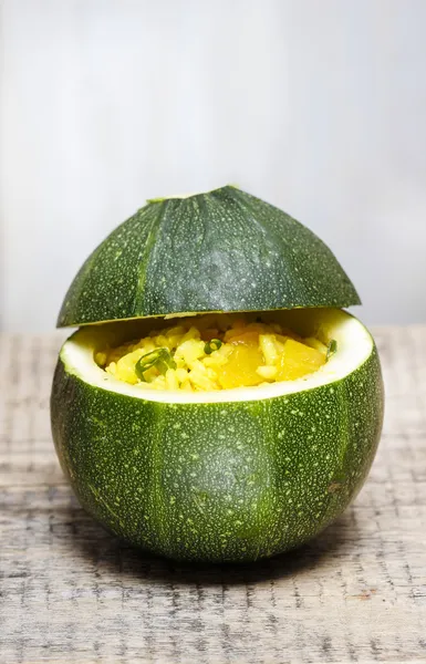 Zucchini stuffed with rice vegetable salad on wooden background. — Stock Photo, Image