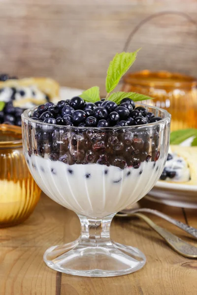 Creamy dessert with blueberries on wooden table. Wooden, rustic — Stock Photo, Image