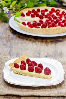 Ahududulu tart ahşap masa üzerinde bir parça. Summer garden parti ayarla