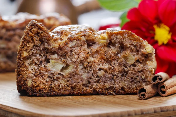 Gâteau à la cannelle sur plateau en bois. Pommes rouges et noix — Photo