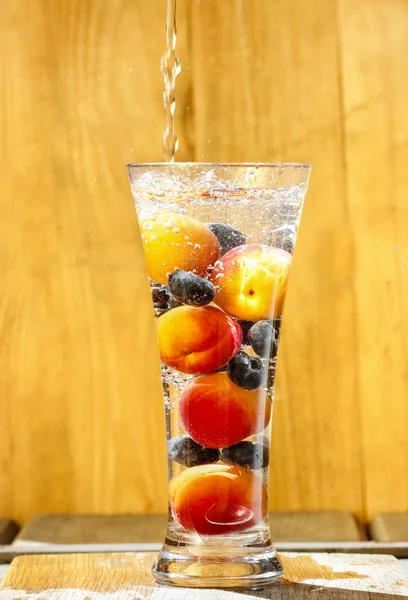 Frutas frescas em copo de água. Refrescamento no dia ensolarado de verão . — Fotografia de Stock