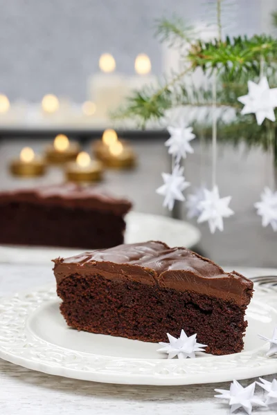 Piece of chocolate cake in white christmas table setting — Stock Photo, Image