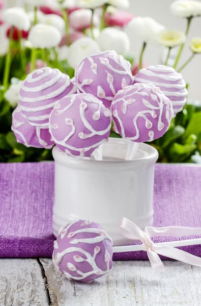 Lilac cake pops in white ceramic jar. White and pink daisies — Stock Photo, Image