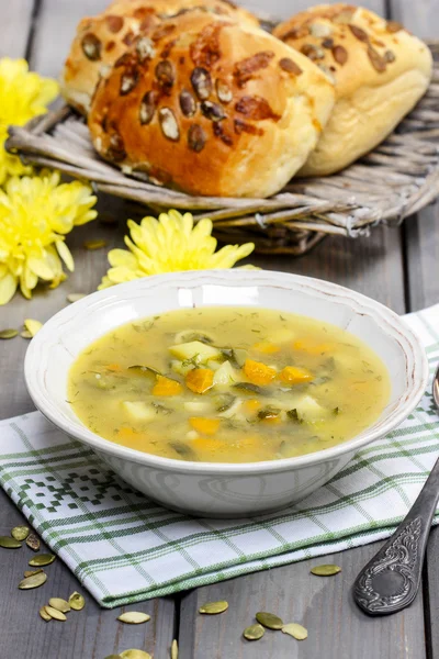 Vegetable soup on wooden table. Basket with fresh buns — Stock Photo, Image