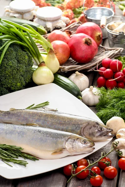 Dos truchas arcoiris crudas y frescas entre las verduras. Idea de saludable — Foto de Stock