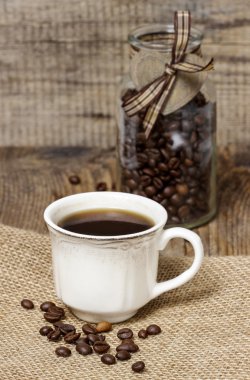 bir fincan kahve kendir peçete üzerinde. kahve çekirdekleri çevresinde