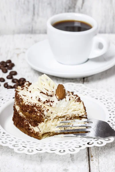 Tiramisu-Kuchen auf weißem Teller. Holzhintergrund, selektiver Fokus — Stockfoto