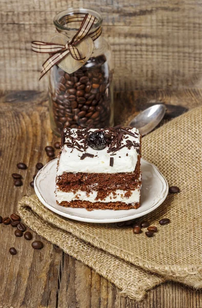 チョコレートとチェリーのケーキ。木の背部のまわりのコーヒー豆 — ストック写真