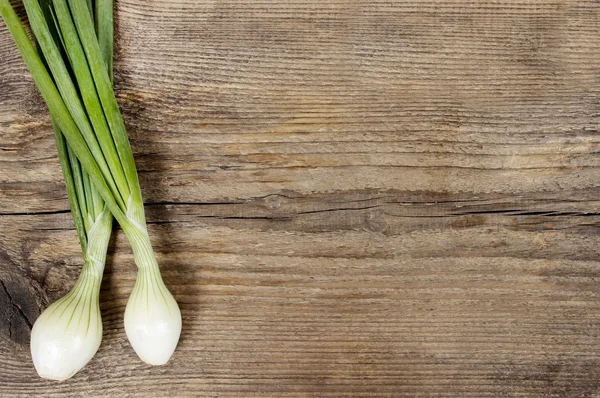 Fresh onion on wooden background. Rough surface, copy space — Stock Photo, Image