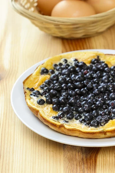 Omelette with blueberries on wooden table — Stock Photo, Image