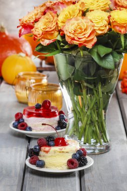 Layer cakes decorated with fresh fruits on rustic wooden table.