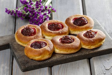 ahşap masa üstünde Erik ile yuvarlak çörekler