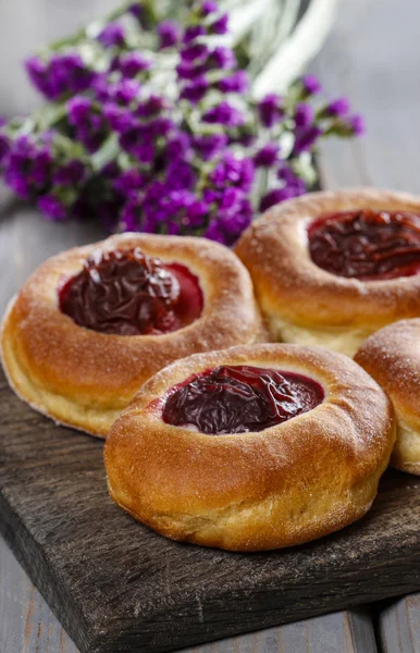 Round buns with plum on wooden table — Stock Photo, Image