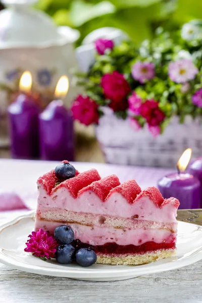 Rosafarbener Schichtkuchen mit frischen Früchten auf Holztisch — Stockfoto