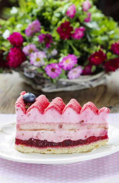 Pink layer cake decorated with fresh fruits on wooden table — Stock Photo, Image