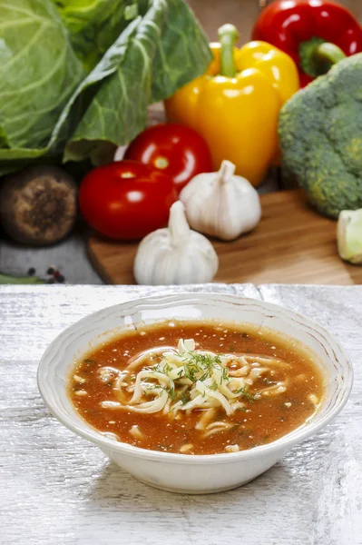 Skål av tomatsoppa och färska grönsaker på gamla träbord — Stockfoto