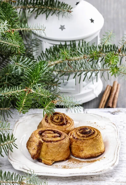 Rolos de canela na mesa de véspera de Natal — Fotografia de Stock