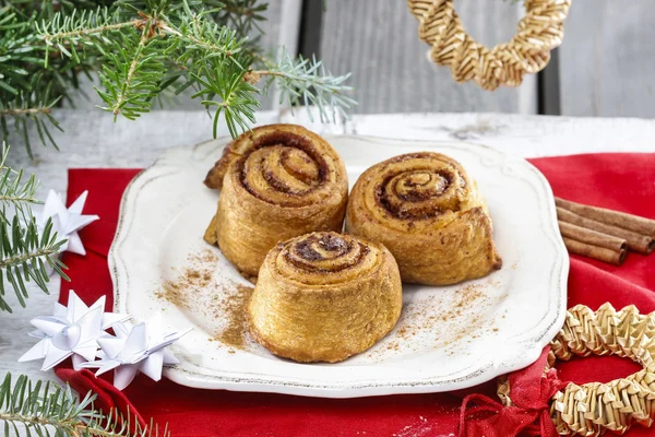 Cinnamon rolls on christmas eve table — Stock Photo, Image