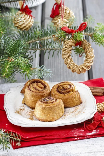 Rollos de canela en la mesa de Nochebuena —  Fotos de Stock